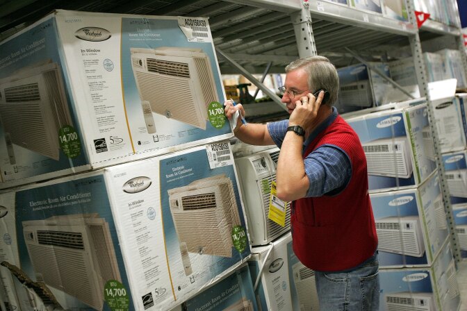Customer Service Associate Doug Ferket talks to a customer on the phone regarding available in-window air conditioners at the Lowe's home improvement store August 2, 2006 in Arlington Heights, Illinois.