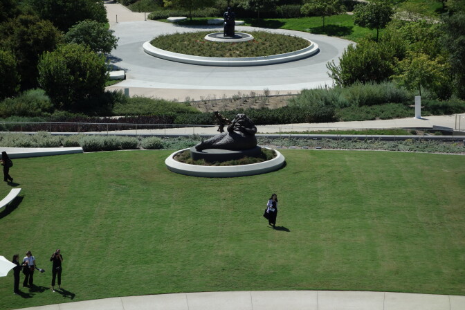 A large green lawn with a metal sculpture of Jabba and Leia from Return of the Jedi where