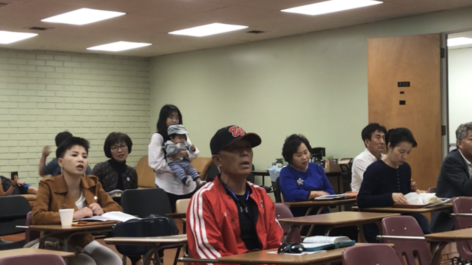 May Joo, far left, sings along in Korean to worship hymns.
