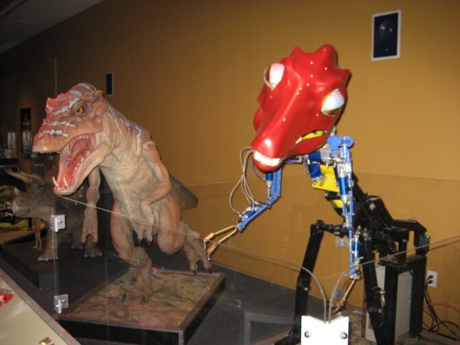 The animatronic skeleton of a dinosaur sits next to one with its "skin" at the movie monster exhibit at the Muzeo in Anaheim.