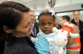 A mother holds her adopted child arriving from Haiti