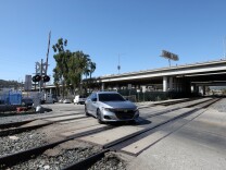 A silver car drives over the Doran Street train crossing in Glendale. 