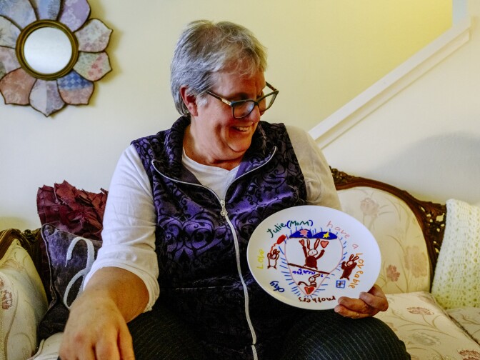 Audrey Woolfolk holds a plate that Julie decorated for a Mother's Day gift when she was younger. 