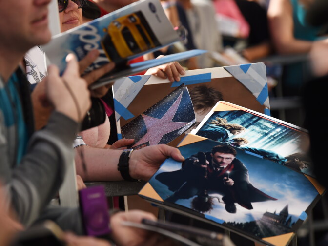 Fans hoping to get a signature from actor Daniel Radcliffe hold Harry Potter photos, at Radcliffe's star unveiling ceremony on the Hollywood Walk of Fame, November 12, 2015 in Hollywood, California. The British actor, best known for the role of Harry Potter, earned the Walk of Fame's 2,565th star, located in front of the Dolby Theatre on Hollywood Boulevard.    AFP PHOTO / ROBYN BECK        (Photo credit should read ROBYN BECK/AFP/Getty Images)