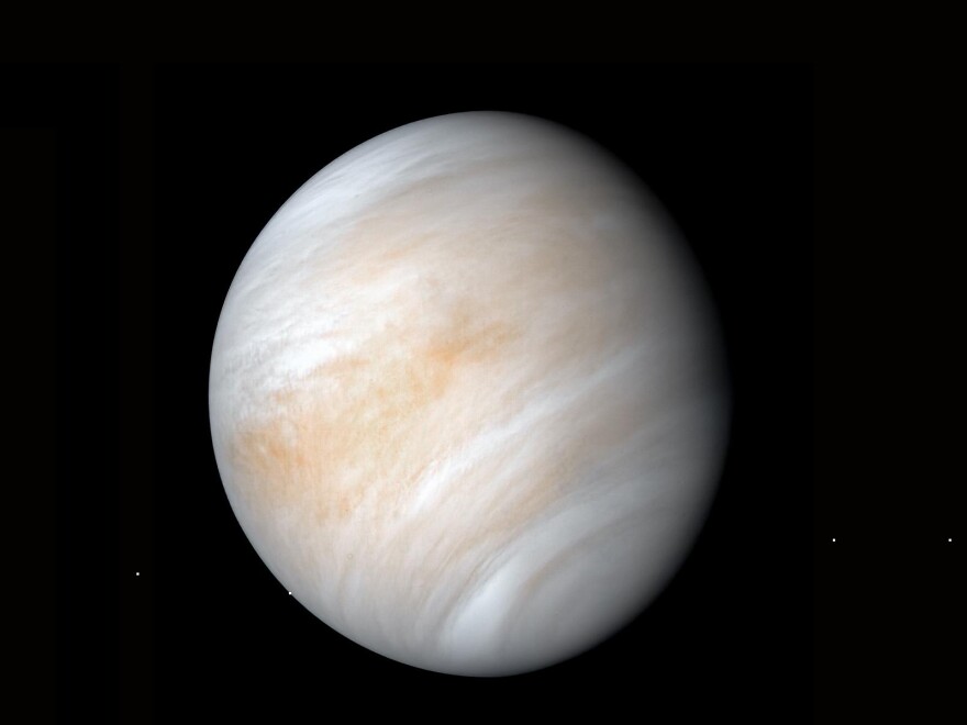 An image of a beige planet with striations against a black background