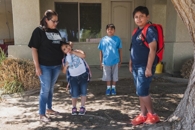 Celisse Cornejo stands with her children Rubi, Alfred, and Jasper outside the two bedroom home where they live along with Cornejo's husband and a nephew on the Fort Yuma Indian Reservation. The Quechan Tribe is using a new tax credit program to fund construction of a 44-unit affordable housing project.  