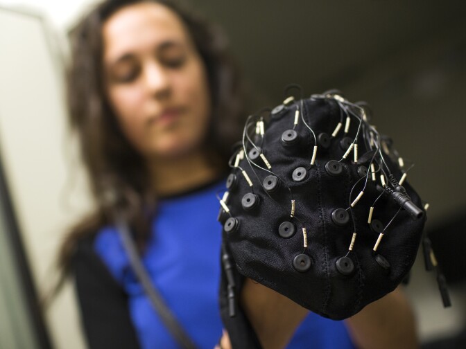 Cara Fesjian, a student researcher at USC, holds an electroencephalography cap used to map children's brain activity at the Brain and Creativity Institute on Wednesday, March 11, 2015. The institute has released a report of interim research findings from a five-year study looking at the emotional, social and cognitive effects of musical training on childhood brain development.