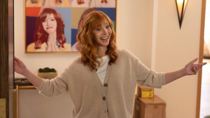 A still from a TV show of a woman smiling big.