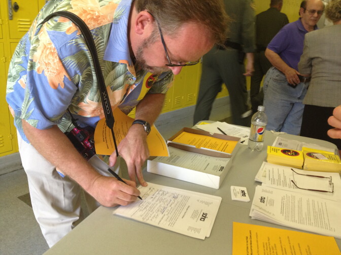 A man signs a petition drawn up by the Sherman Oaks Homeowners Association that outlines suggestions for how the Federal Aviation Administration should regulate helicopters in Los Angeles. 