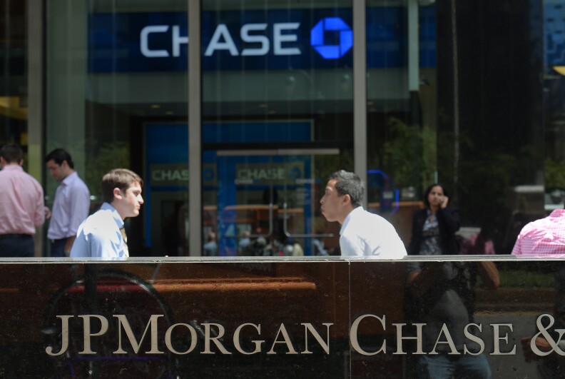 People walk by JP Morgan Chase & Company headquarters in New York, August 14, 2013. The US August 14, 2013 charged a pair of former JPMorgan Chase traders with fraud in connection with the 2012 $6.2 billion 'London whale' trading losses. Federal prosecutors filed criminal charges against Javier Martin-Artajo and Julien Grout, alleging the two men kept false records on the trades, committed wire fraud and submitted false US securities filings.