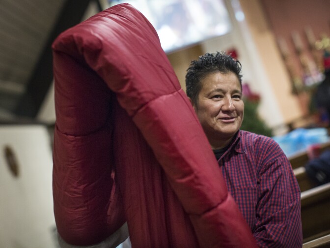 Zonia Sotelo lays out her sleeping bag at All Saints' Episcopal Church in Highland Park on Tuesday night, Dec. 22, 2015. Sotelo lost her home in Pasadena at the beginning of 2015. She hopes to get a new place with her son soon.