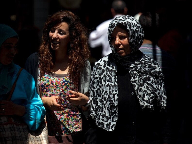 Tunisian women walk through the narrow streets of Tunis' medina, or marketplace. Compared to women in other Arab countries, Tunisian women have had access to education and job opportunities for decades.