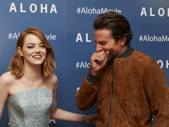 Actors Emma Stone (L) and Bradley Cooper (R) laugh together arriving to attend a special screening of the film "Aloha" in London on May 16, 2015.