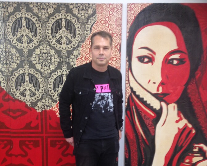 Shepard Fairey with one of his paintings that will be on display in the Beyond the Streets exhibit