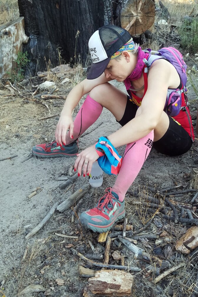 Runner Martine Sesma sits alongside the trail course at about mile 51 of the Angeles Crest 100 trying to gather the strength to continue the run.