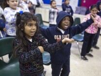 First graders Sherlyn Asuna, left, and Jaden Armstrong practice a holiday song at Martin Luther King Elementary School in Compton on Friday morning, Dec. 5, 2014.