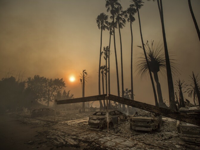 Smoke rises behind a leveled apartment complex as a wildfire burns in Ventura, Calif., on Tuesday, Dec. 5, 2017. Over 100 structures have burned so far in Ventura County, officials said. 