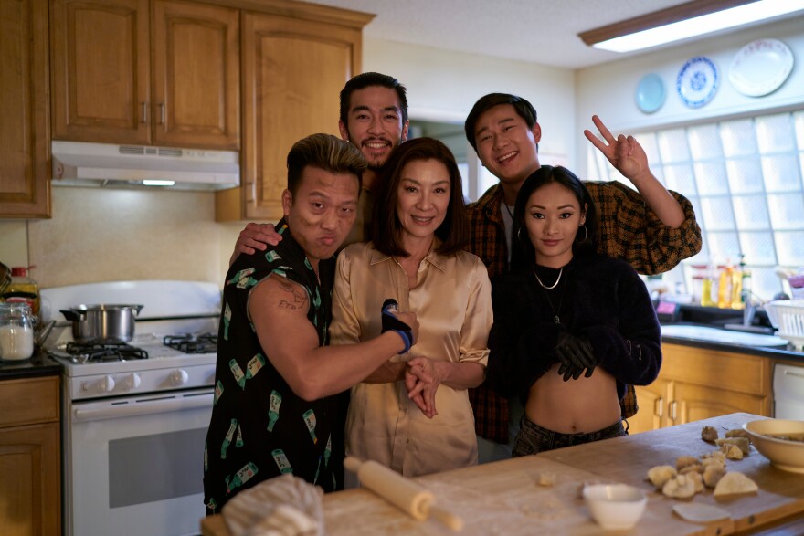 Five people take a photo together.