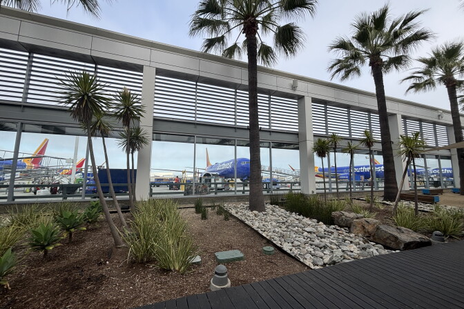 Southwest Airlines planes are parked on a tarmac outside a passenger terminal