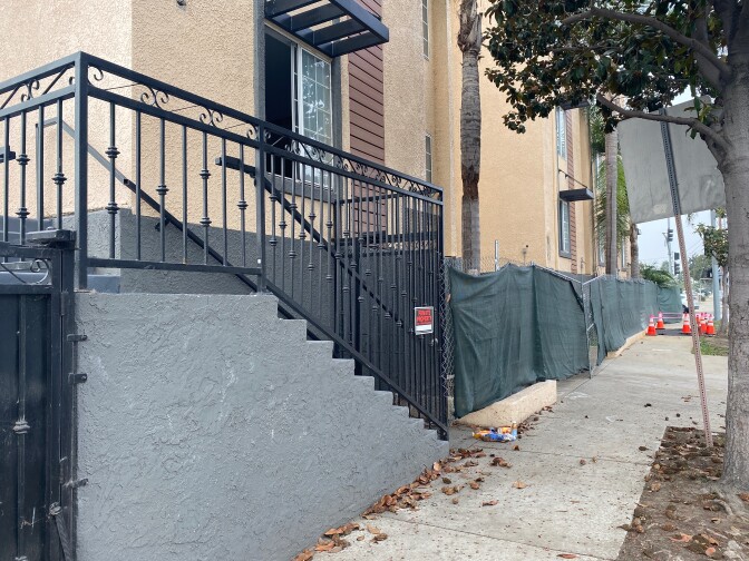 A former hotel is under renovation. Shown is the sidewalk and the fencing around the property while construction is ongoing. 