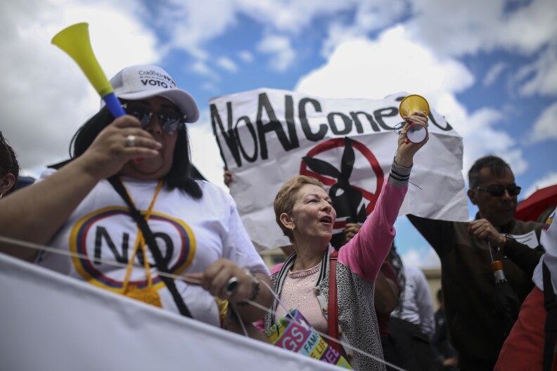 Opponents of peace agreements between rebels of the Revolutionary Armed Forces of Colombia, FARC, with the government gather outside the congress in Bogota, Colombia, Wednesday, Nov. 30, 2016. Colombia's congress is debating a modified peace accord between the government and FARC rebels, with an eye toward ratifying a deal that was rejected by voters in a referendum less than two months ago. (AP Photo/Ivan Valencia)