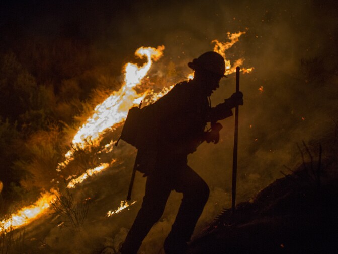 BURBANK, CA - SEPTEMBER 02: A firefighter climbs a burning hillside after having fallen into a hole fighting while the La Tuna Fire on September 2, 2017 near Burbank, California. Los Angeles Mayor Eric Garcetti said at a news conference that officials believe the fire, which is at 5,000 acres and growing, is the largest fire ever in L.A. People have been evacuated from hundreds of homes in Sun Valley, Burbank and Glendale. About 100 Los Angles firefighters are expected to return soon from Texas, where they've been helping survivors from Hurricane Harvey.    (Photo by David McNew/Getty Images)