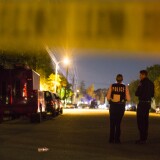 Redlands Police stand near Center Street and Pine Avenue on Wednesday night, Dec. 2, 2015 as authorities serve a search warrant following a mass shooting inside the the Inland Regional Center in San Bernardino on Wednesday, Dec. 2, 2015.