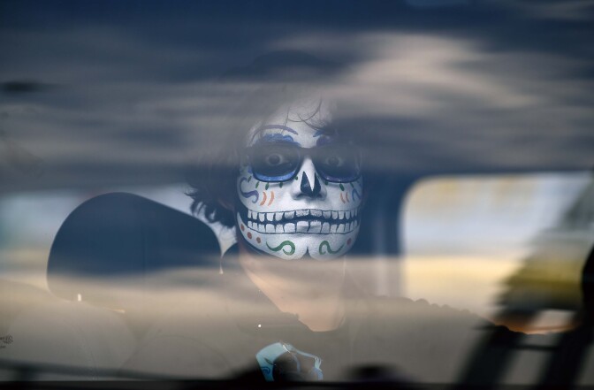 A man with his face painted arrives at Dolores cemetery during All Saints Day in Mexico City on November 1, 2016.