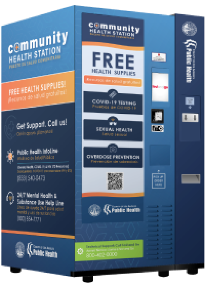 A blue and orange vending machine reads "community health clinic" and "free health supplies" on the front. 