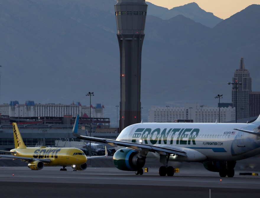 A Frontier Airlines plane (right) prepares to take off from Harry Reid International Airport in Las Vegas, Nevada.