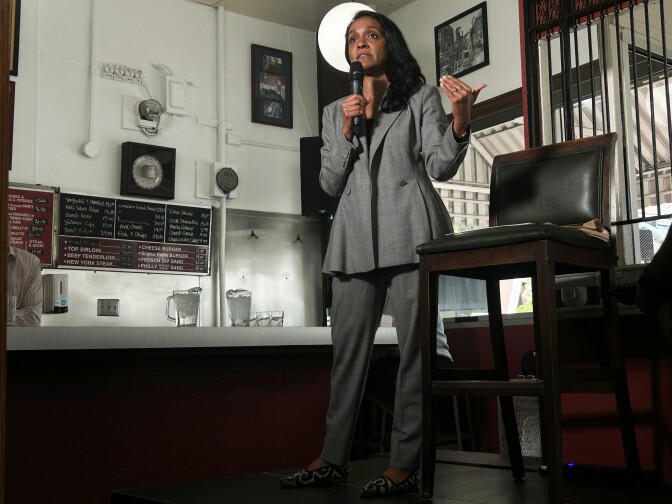 Woman in grey suit on stage. 