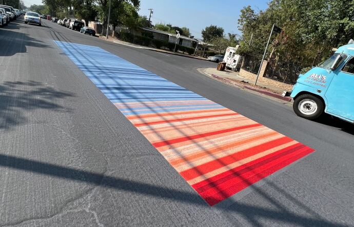 A street painted with bright red and baby blue colors symbolizing a heat scale.
