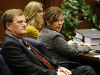 Former assistant city manager of Bell, Angela Spaccia, center, who is charged with misappropriation of public funds and other counts, listens to opening statements in Los Angeles Superior Court, Wednesday, Oct. 23, 2013.