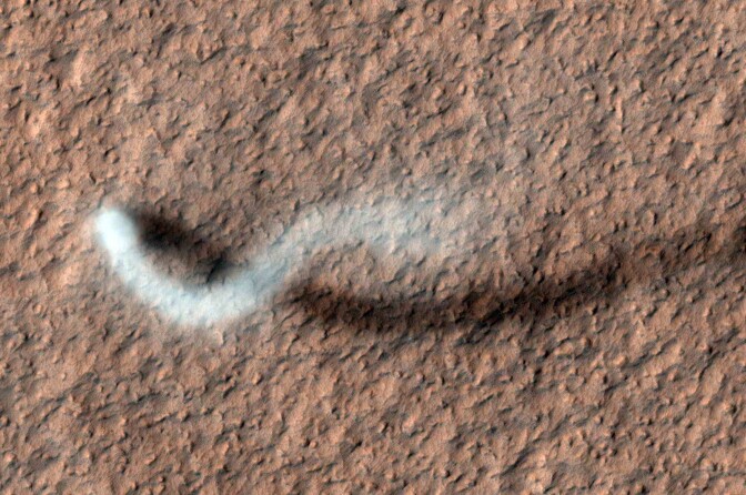 A smoky trail is visible in a serpentine shape against a red surface