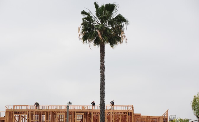 Construction workers are seen atop a builing of new apartments for sale in Alhambra, east of downtown Los Angeles, on March 23, 2012. Sales of new homes in the United States slipped for the second straight month in February but the median price of homes sold picked up sharply, according to the Commerce Department.    AFP PHOTO/Frederic J. BROWN (Photo credit should read FREDERIC J. BROWN/AFP/Getty Images)