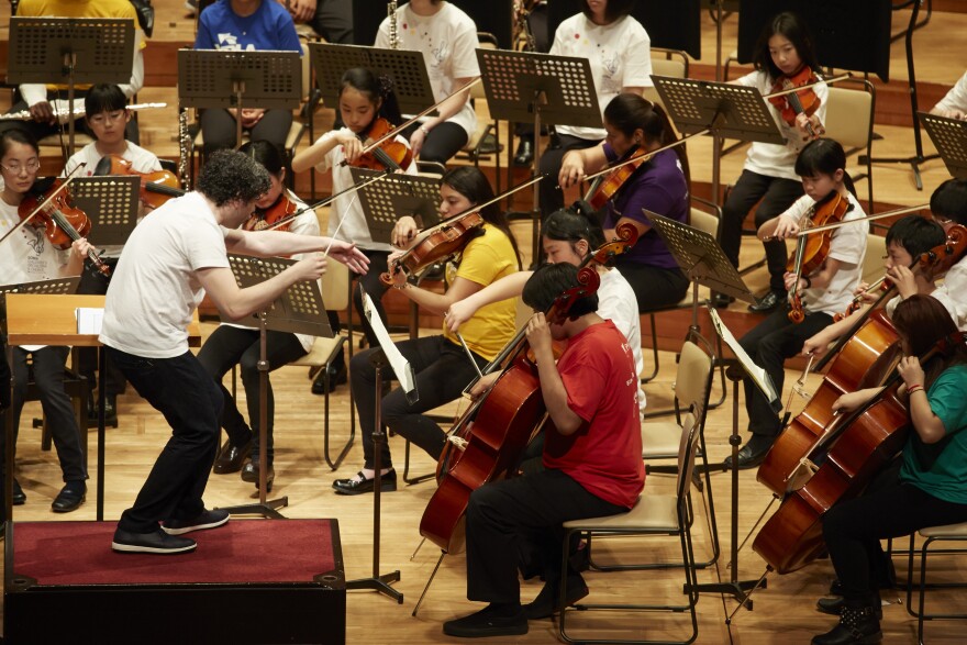 LA Philharmonic's music and artistic director Gustavo Dudamel conducts a rehearsal at Tokyo's Suntory Hall with an orchestra comprised of children from Youth Orchestra L.A. (YOLA) and from the El Sistema orchestra in Soma, Japan.