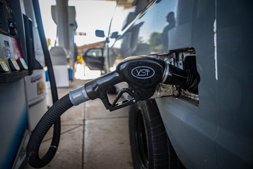 A gas nozzle placed in a van at a gas station.