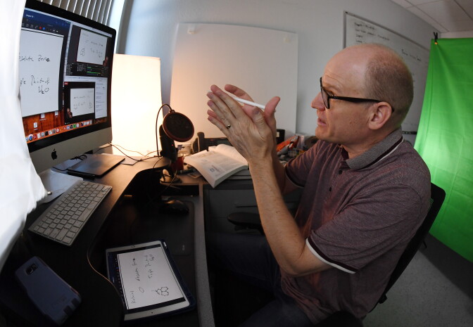 LAS VEGAS, NEVADA - SEPTEMBER 01:  (EDITORS NOTE: This image was shot with a fisheye lens.) Professor of physics and astronomy Dr. Jason Steffen teaches a remote Physics for Scientists and Engineers course from his office at UNLV amid the spread of the coronavirus (COVID-19) on September 1, 2020 in Las Vegas, Nevada. To lower the number of people on campus to allow for social distancing because of the pandemic, the university moved fall 2020 courses with more than 50 students, about 80 percent of its classes, to remote instruction, with 20 percent of courses held in-person or hybrid. UNLV is only using large classrooms with spaced out seating and under 50 percent capacity for in-person classes, which are now staggered to reduce density on the campus.  (Photo by Ethan Miller/Getty Images)