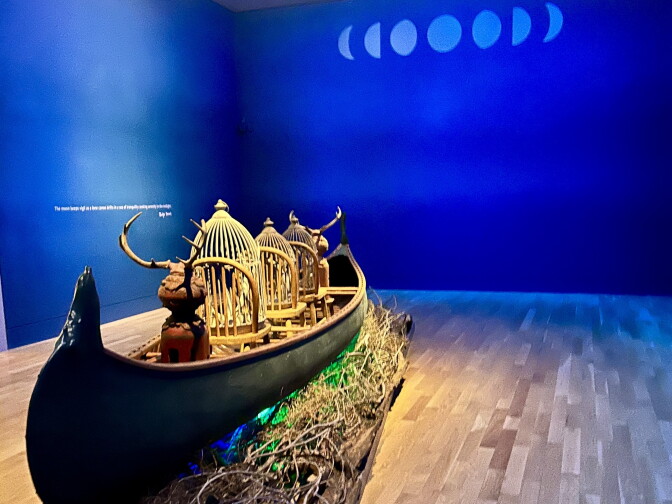 A wood canoe in a room painted blue.