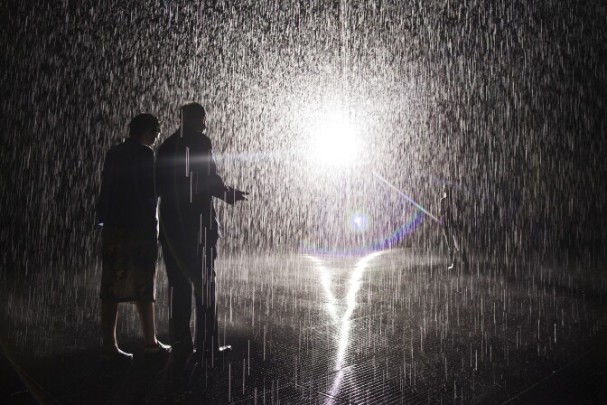 A security guard walks a press preview attendee through the Rain Room at LACMA on Wednesday morning, Oct. 28, 2015. The installation is located on the first floor of the Broad Contemporary Art Museum building.