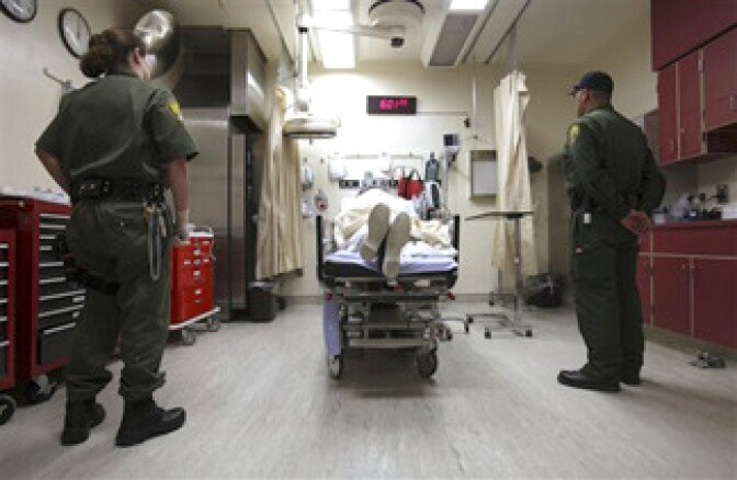 Correctional officers stand watch over an inmate receiving treatment in the emergency room at California State Prison, Corcoran, in Corcoran, Calif., Wednesday, Jan. 14, 2009. 