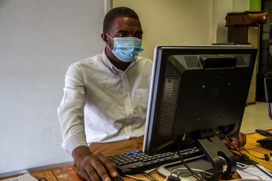HARARE, ZIMBABWE - JANUARY 05: A man is seen working wearing a mask in his office during the lockdown on January 5, 2021 in Harare, Zimbabwe. Following crowded new year's eve celebrations where coronavirus sanitary protocols were scarce, the Zimbabwe's capital has entered a strict 30-day lockdown. As of 3rd January, Zimbabwe recorded 15,265 Covid-19 infection cases and 380 deaths. (Photo by Tafadzwa Ufumeli/Getty Images)
