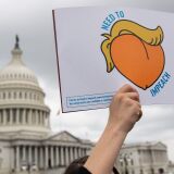 A woman holds a sign during a press conference where activist delivered a computer flash drive to lawmakers at the US Capitol in Washington, DC, May 9, 2019. - The drive contains 10 million signatures on a petition urging the US Congress to begin impeachment proceedings against US President Donald Trump. (Photo by SAUL LOEB / AFP)        (Photo credit should read SAUL LOEB/AFP/Getty Images)