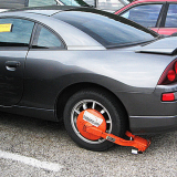 A impounded vehicle with a boot is seen in a tow yard. 