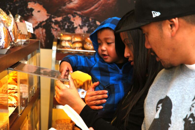 WEST COVINA, Calif. -- Jayden, age 2, helps his mother Channthy Peav of Baldwin Park select baked goods in the storefront of 85°C Bakery Cafe on Jan. 16. This company-owned West Covina location is the third to open in the United States, with more openings planned throughout Southern California. The Taiwan-based chain, while new to the U.S. market, operates more than 700 stores worldwide.
