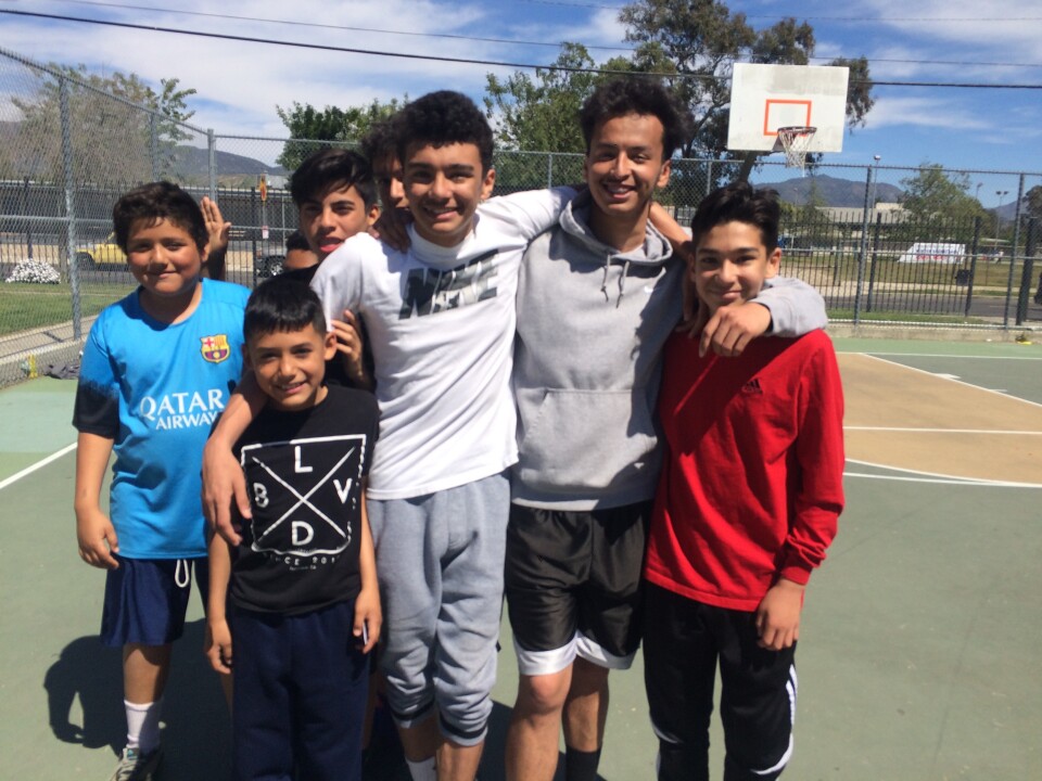 Jaime Zombrano, 17, second from right, takes a break from playing basketball with his friends at San Fernando Gardens housing in Pacoima. The neighborhood has gotten much safer from when he was a kid, though a deadly shooting of a teen in October 2015 on the block brought back bad memories, he said. 