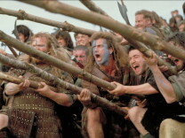 A color picture of Mel Gibson as William Wallace alongside other 13th century fighters from a battle scene in 1995's "Braveheart."