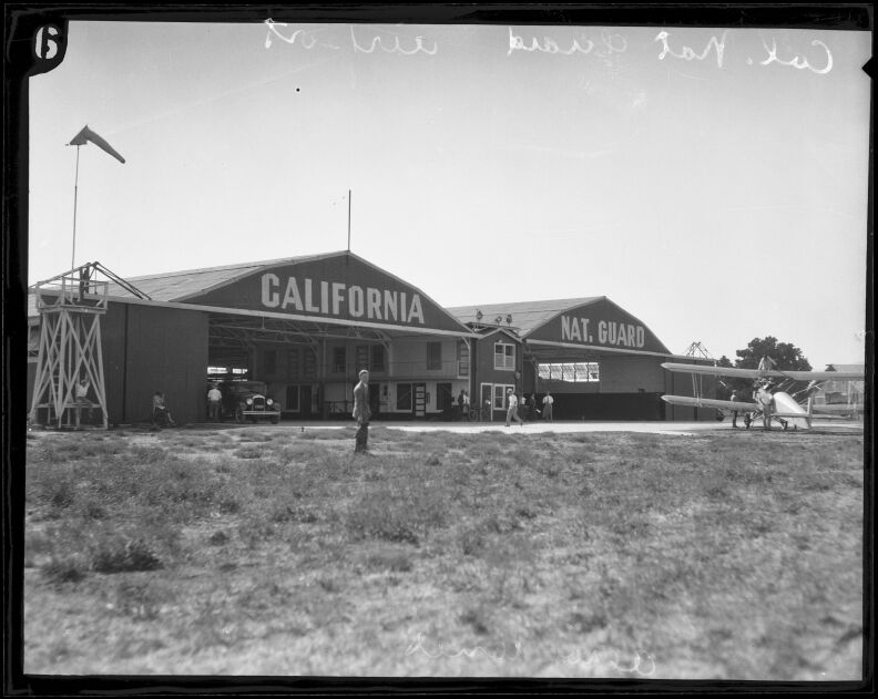 Two airplane hangars are marked California National Guard in a black and white photo.