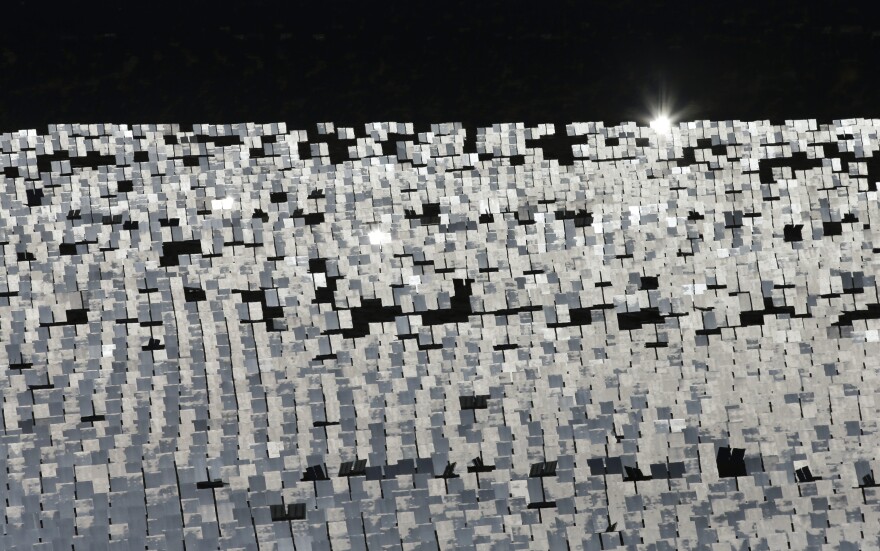 Some of the 300,000 computer-controlled mirrors, each about 7 feet high and 10 feet wide, reflect sunlight to boilers that sit on 459-foot towers. The sun's power is used to heat water in the boilers' tubes and make steam, which in turn drives turbines to create electricity Tuesday, Feb. 11, 2014 in Primm, Nev. The Ivanpah Solar Electric Generating System, sprawling across roughly 5 square miles of federal land near the California-Nevada border, will be opened formally Thursday after years of regulatory and legal tangles. (AP Photo/Chris Carlson)
