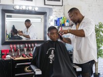 Corey Thomas works on a client at A New You barbershop in Inglewood.